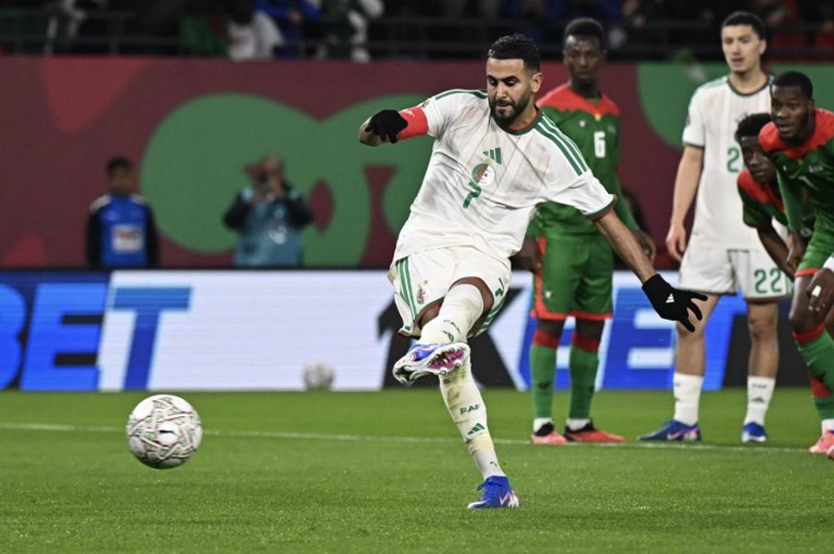 Algeria's forward #7 Riyad Mahrez (L) shoots and scores his team's first goal from the penalty spot during the Africa Cup of Nations (CAN) Group E football match between Algeria and Burkino Faso at Moulay Hassan Stadium in Rabat on December 28, 2025. Paul ELLIS / AFP