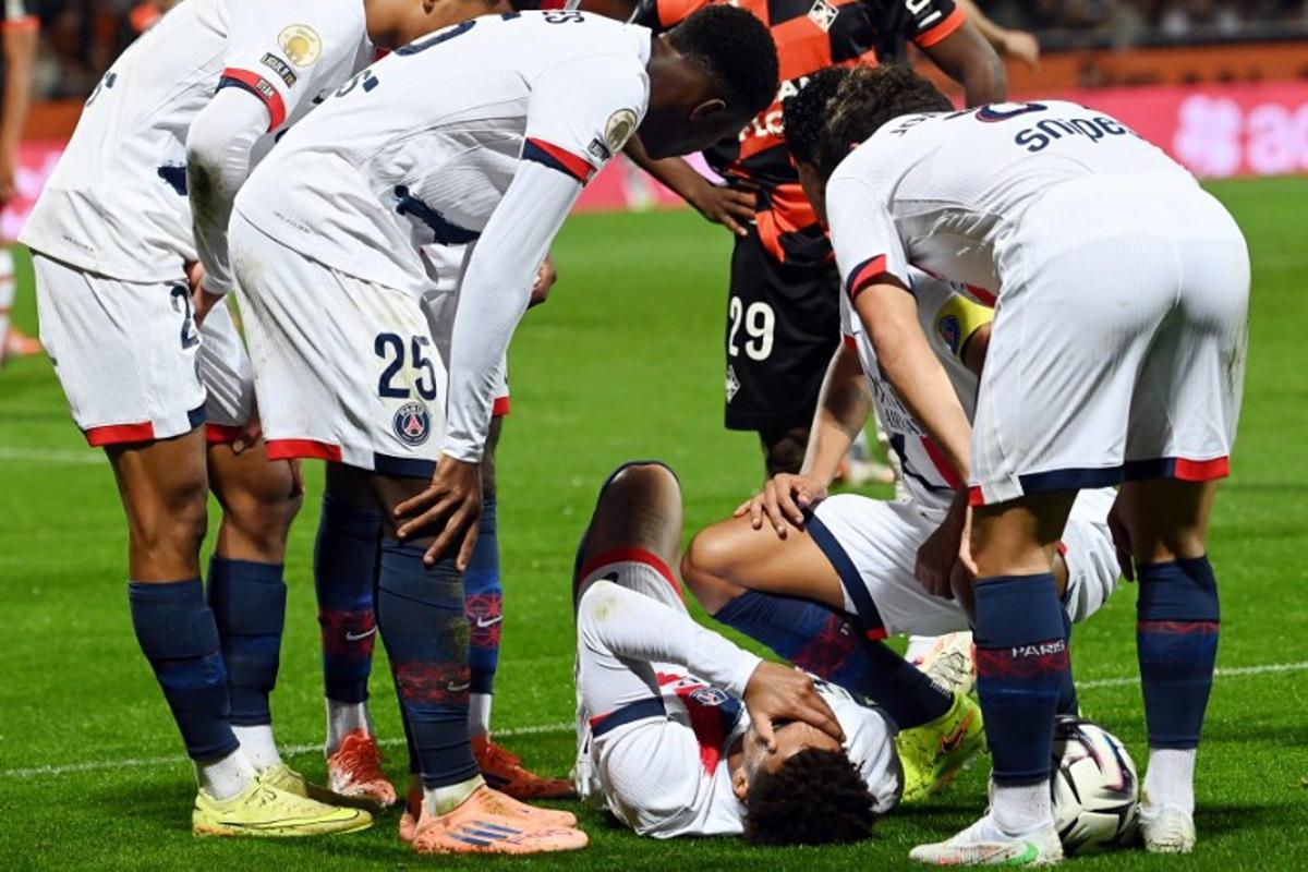 Paris Saint-Germain's French midfielder #14 Desire Doue (C) reacts in pain after suffering an injury during the French L1 football match between FC Lorient and Paris Saint-Germain (PSG) at the Stade du Moustoir in Lorient, western France, on October 29, 2025. JEAN-FRANCOIS MONIER / AFP