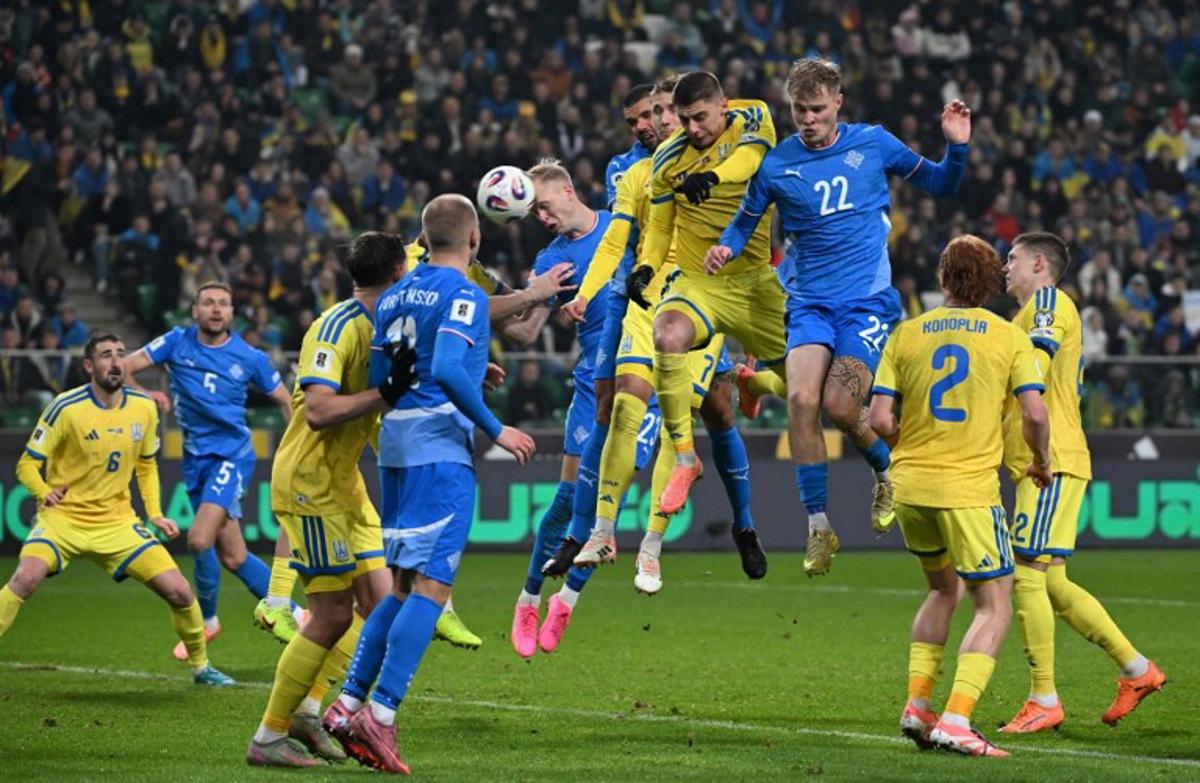 Iceland's defender #23 Hordur Magnusson (C L) heads the ball during the FIFA World Cup 2026 Group D European qualification football match betweem Ukraine and Iceland in Warsaw, Poland on Novmeber 16, 2025. Sergei GAPON / AFP