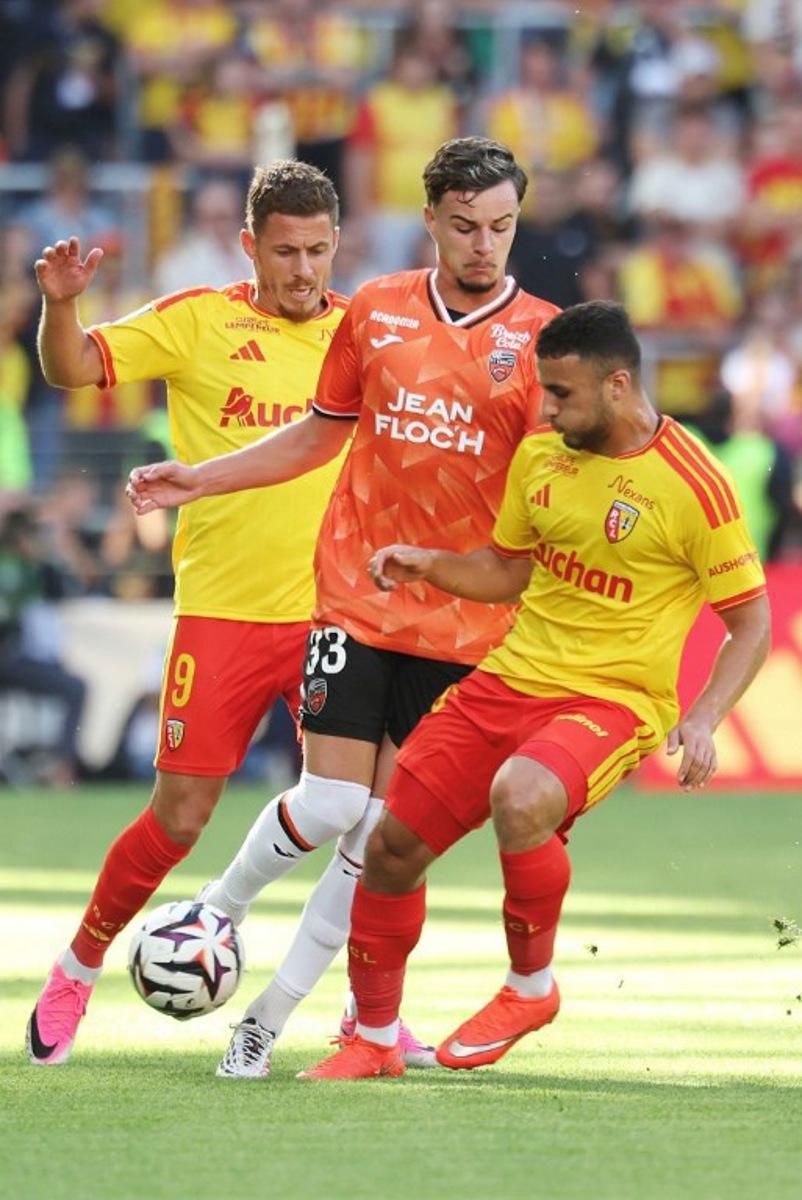 Lens' Belgian midfielder #09 Thorgan Hazard (L) and Lens' Algerian midfielder #08 Yacine Titraoui (R) fight for the ball with Lorient's French midfielder #33 Gabin Bernardeau (C) during the French L1 football match between RC Lens and FC Lorient at the Stade Bollaert-Delelis in Lens, northern France, on September 5, 2026. Francois LO PRESTI / AFP