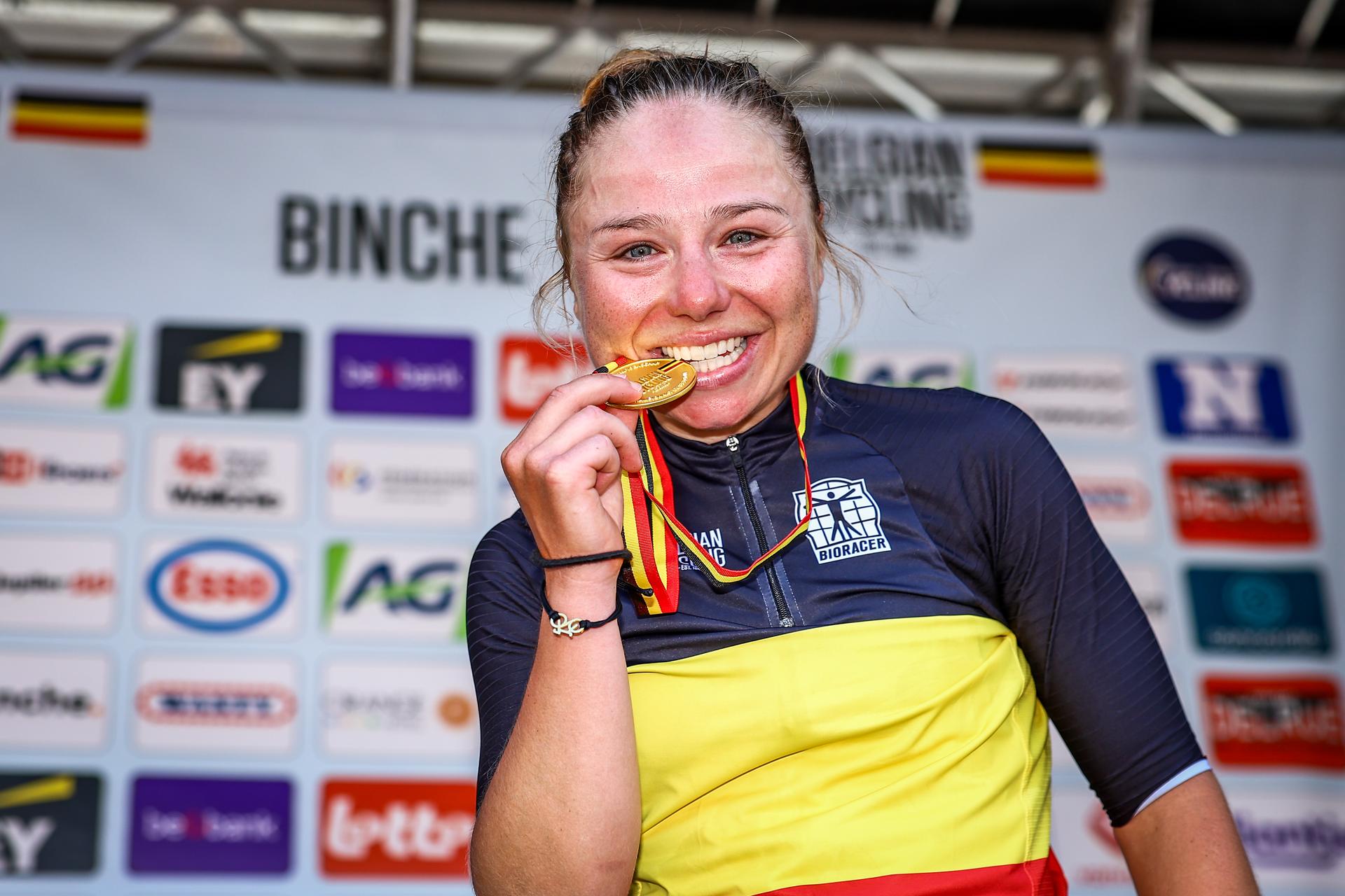 Belgian Justine Ghekiere celebrates on the podium with the gold medal and the national jersey after winning the women's elite road race of the Belgian Cycling Championships, 132,8 km from and to the Grand Place square in Binche on Sunday 29 June 2025. BELGA PHOTO DAVID PINTENS