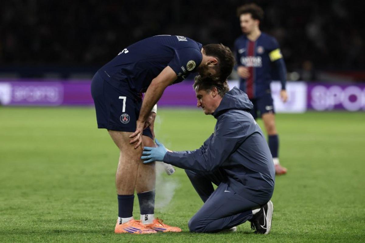 (FILES) Paris Saint-Germain's Georgian forward #07 Khvicha Kvaratskhelia receives medical assistance after suffering an injury during the French L1 football match between Paris Saint-Germain (PSG) and Auxerre at the Parc des Princes stadium in Paris on September 27, 2025. Kvaratskhelia, absent for the trip to Barcelona ahead of the UEFA Champions League first round day 2 football match. FRANCK FIFE / AFP
