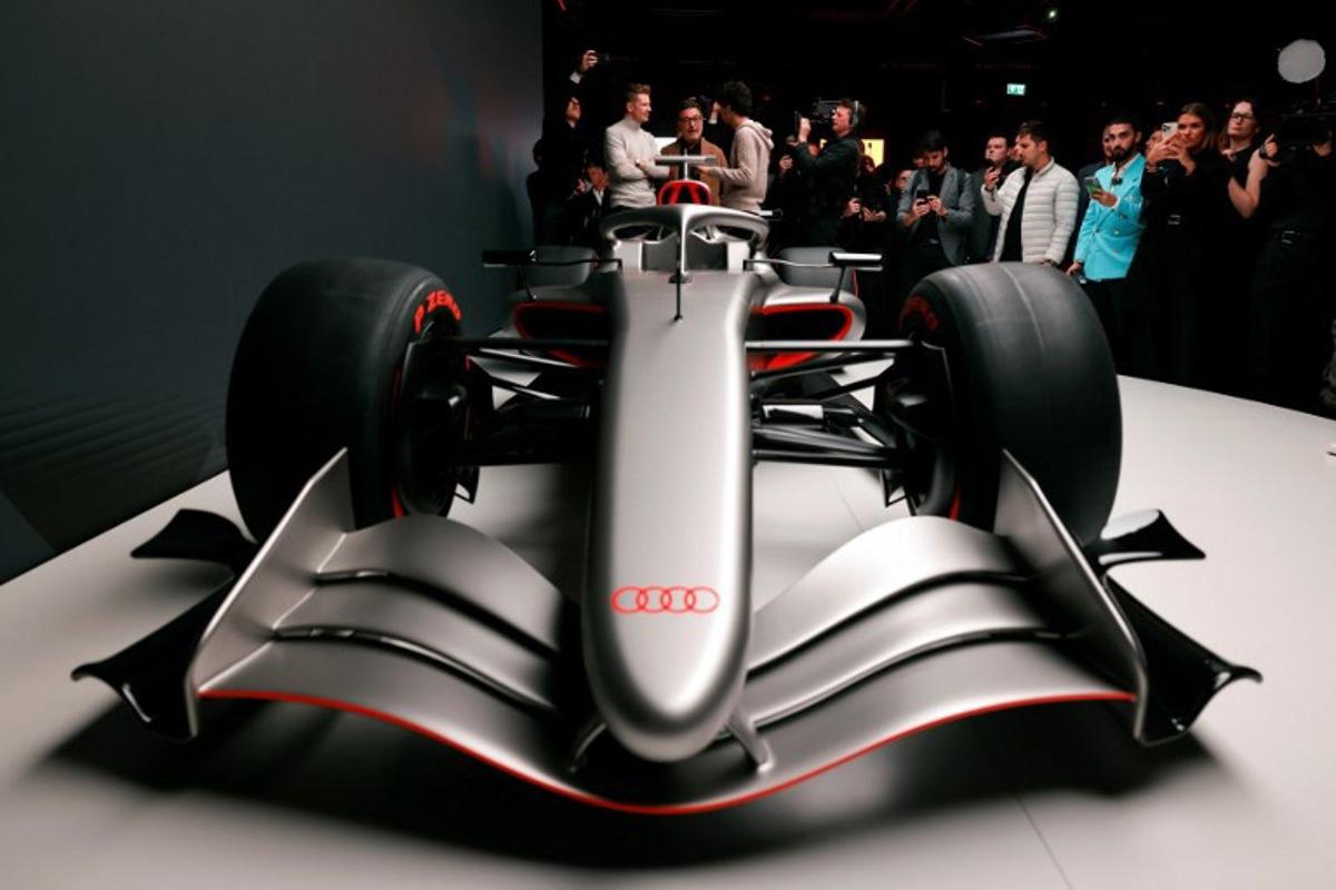 Massimo Frascella (C), Chief Creative Officer at AUDI AG, together with Kick Sauber's German driver Nico Hulkenberg (L) and Kick Sauber's Brazilian driver Gabriel Bortoleto (R) unveils the F1 car of the Audi F1 factory team set to compete in the Formula One starting in the 2026 season in Munich, southern Germany on November 12, 2025. Alexandra BEIER / AFP