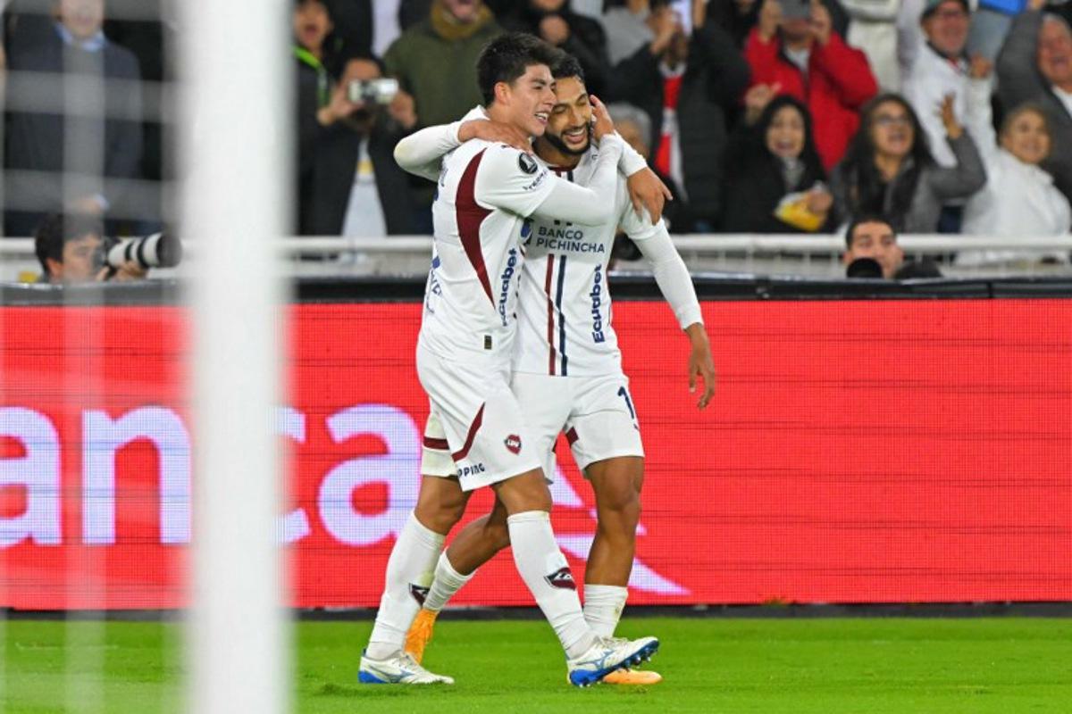 Liga de Quito's Bolivian midfielder #15 Gabriel Villamil (L) celebrates with teammate Colombian forward #16 Jeison Medina scoring his team's third goal during the Copa Libertadores semifinal first leg football match between Ecuador's Liga de Quito and Brazil's Palmeiras at the Rodrigo Paz Delgado stadium in Quito on October 23, 2025. Rodrigo BUENDIA / AFP