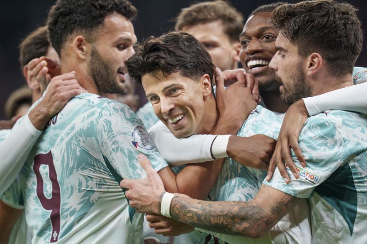 Portugal's defender #20 Joao Cancelo (C) celebrates scoring the opening goal with his teammates during the UEFA Nations League Group A4 match between Denmark and Portugal at Parken stadium in Copenhagen on October 1, 2026. Liselotte Sabroe / Ritzau Scanpix / AFP