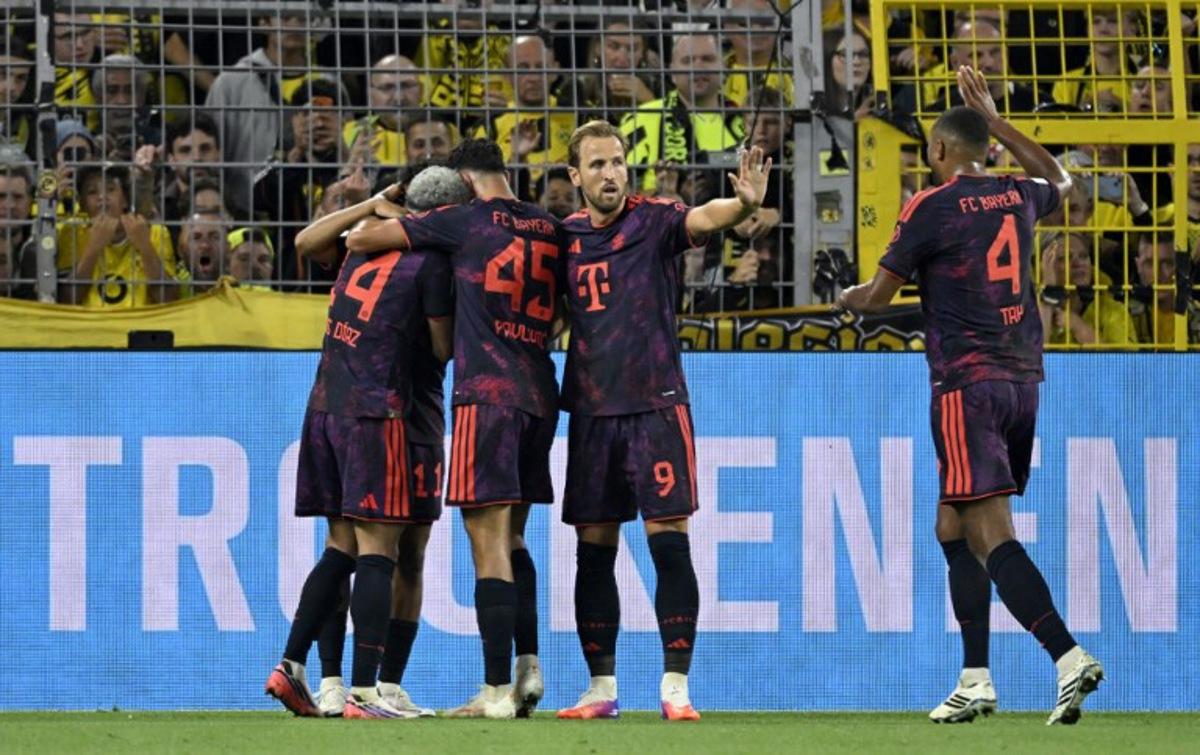 (R-L) Bayern Munich's German defender #04 Jonathan Tah, Bayern Munich's English forward #09 Harry Kane, Bayern Munich's German midfielder #45 Aleksandar Pavlovic and Bayern Munich's Colombian forward #14 Luis Diaz celebrate after their team scored the 0-1 goal during the Franz Beckenbauer Supercup football match between Borussia Dortmund and FC Bayern Munich on August 22, 2026 in Dortmund, western Germany. INA FASSBENDER / AFP