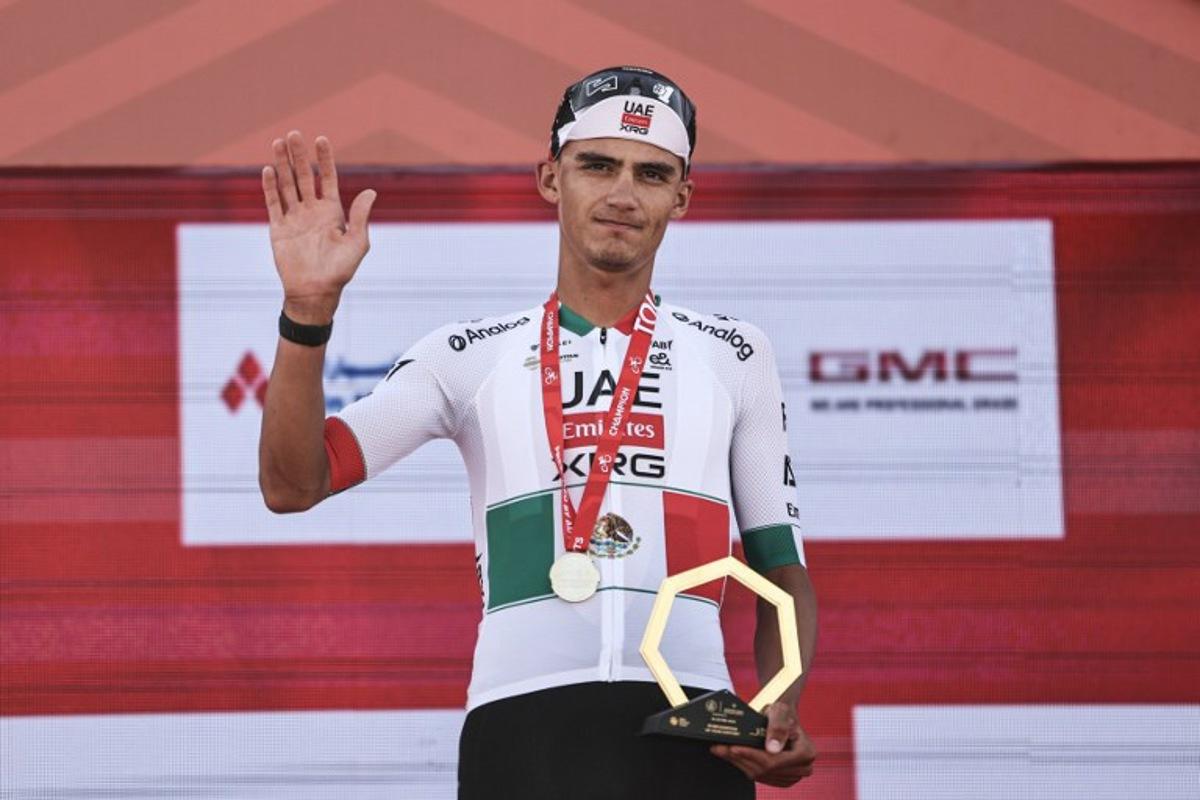 UAE Team Emirates's Mexican rider Isaac Del Toro Romero celebrates with his trophy after winning the first stage of the UAE Tour cycling event from Madinat Zayed Majlis to Liwa Palace in Abu Dhabi on February 16, 2026. Fadel SENNA / AFP