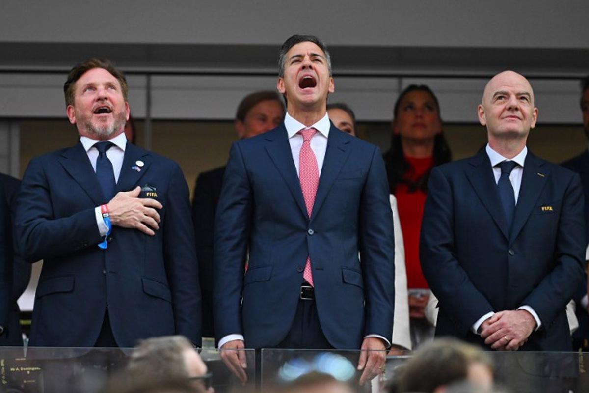 (L-R) CONMEBOL President Alejandro Dominguez and Paraguayan President Santiago Pena sing the Paraguayan national anthem next to FIFA president Gianni Infantino ahead of the 2026 World Cup Group D football match between USA and Paraguay at the Los Angeles Stadium in Inglewood on June 12, 2026. Patrick T. Fallon / AFP
