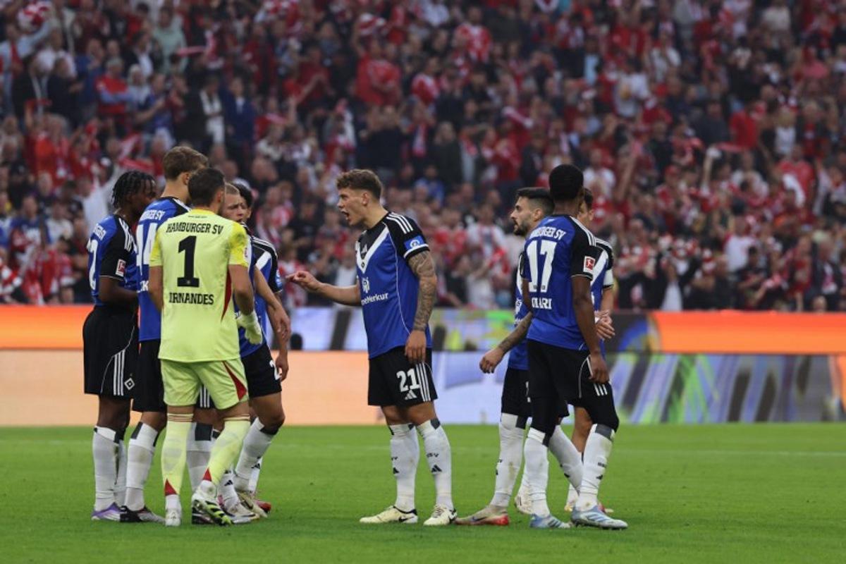 Hamburg's German midfielder #21 Nicolai Remberg (C) argues during the German first division Bundesliga football match between FC Bayern Munich and HSV Hamburg in Munich, southern Germany, on September 13, 2025. Alexandra BEIER / AFP