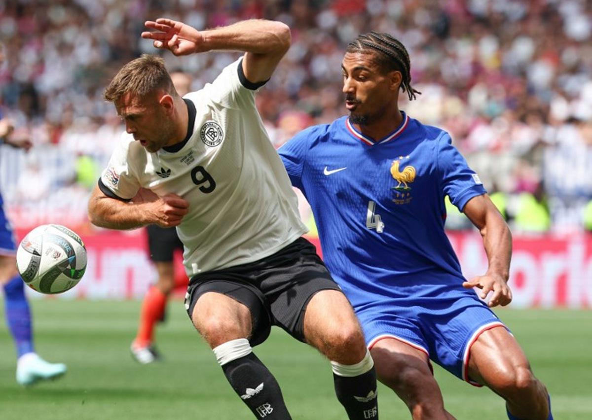 Germany's forward #09 Niclas Fullkrug (L) and France's defender #04 Loic Bade vie for the ball during the UEFA Nations League third place play-off football match between Germany and France in Stuttgart, southwestern Germany on June 8, 2025. FRANCK FIFE / AFP