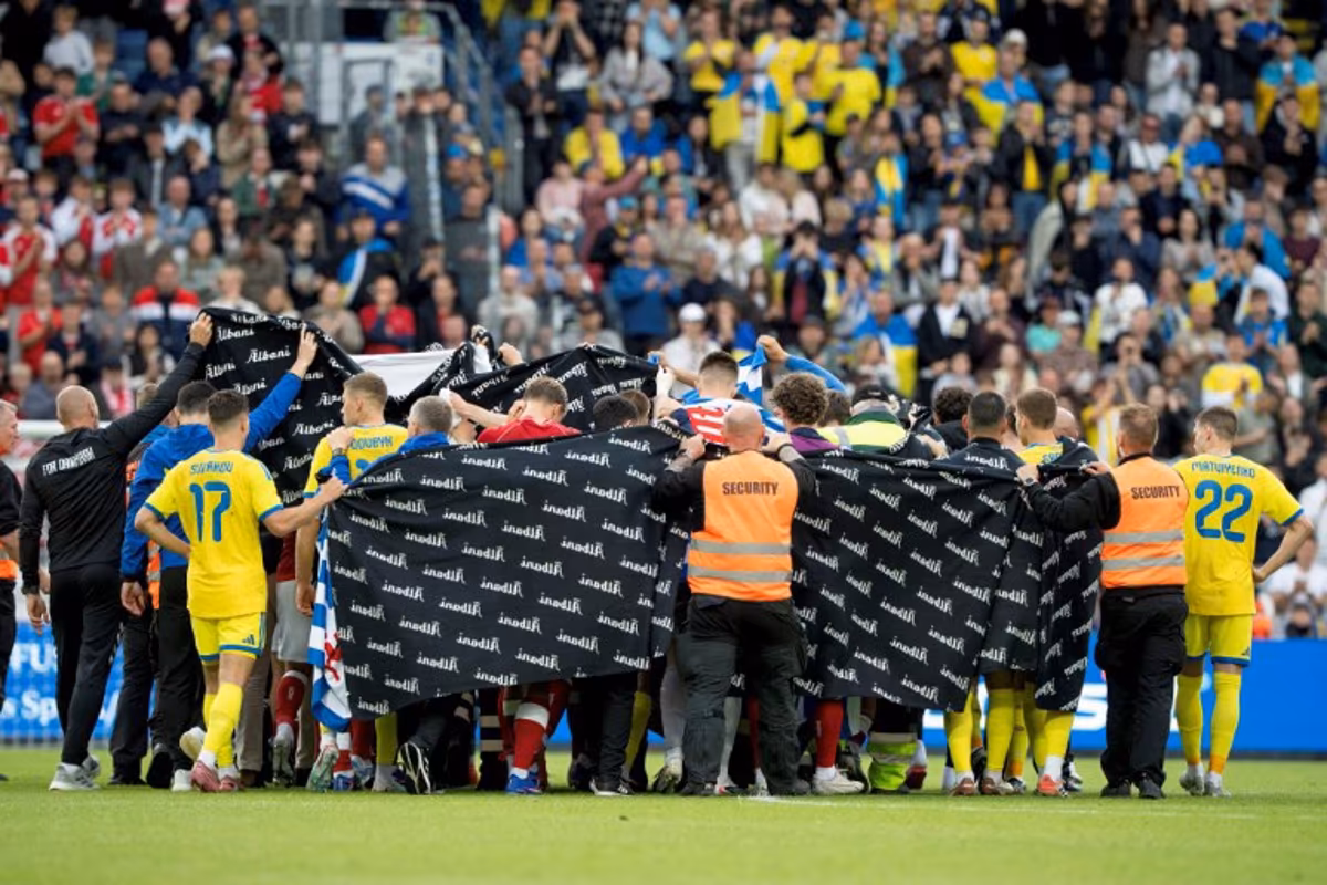 Denmark's and Ukraine's players huddle to accompany Denmark's midfielder #10 Christian Eriksen to a waiting ambulance during the football international friendly match between Denmark and Ukraine at Odense Stadium in Denmark, on June 7, 2026. Christian Eriksen collapsed during Denmark's friendly against Ukraine on June 7, 2026, five years after he suffered a cardiac arrest during the European Championships. Bo Amstrup / Ritzau Scanpix / AFP