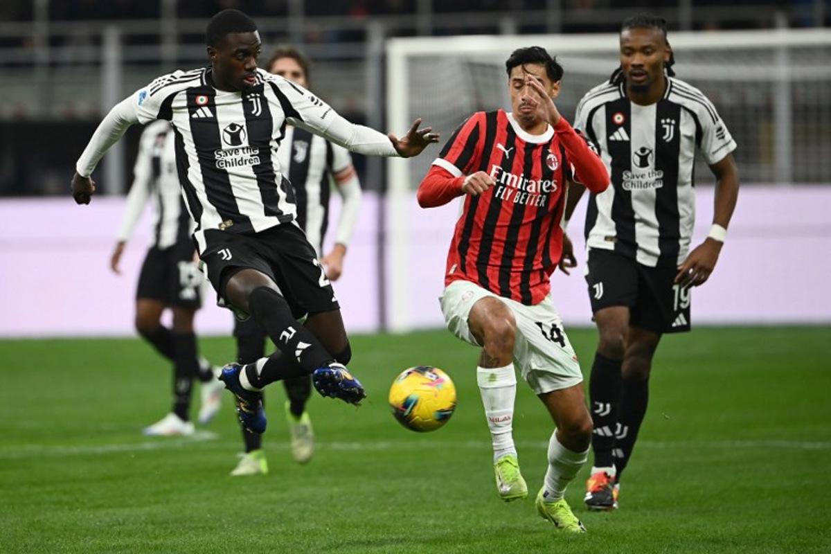 Juventus' US forward #22 Timothy Weah (L) fights for the ball with AC Milan's Dutch midfielder #14 Tijani Reijnders during the Italian Serie A football match between AC Milan and Juventus Turin at San Siro stadium in Milan, on November 23, 2024. Isabella BONOTTO / AFP