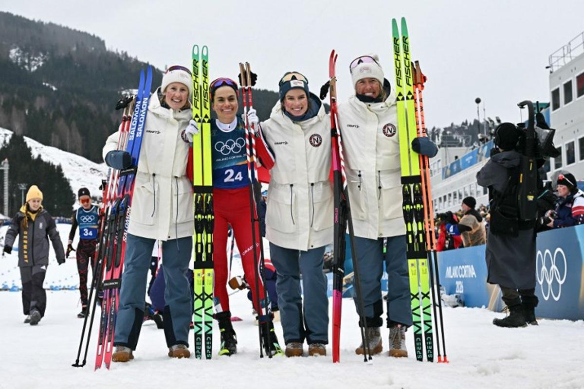 Norway's Heidi Weng (2ndL) poses with her teammates (From L) Norway's Karoline Simpson-Larsen, Norway's Kristin Austgulen Fosnaes and Norway's Astrid Oeyre Slind after she crossed the finish line for Norway to win the gold medal during the cross-country women's 4 x 7,5km relay event of the Milano Cortina 2026 Winter Olympic Games at Tesero Cross-Country Skiing Stadium in Lago di Tesero (Val di Fiemme), on February 14, 2026. Javier SORIANO / AFP