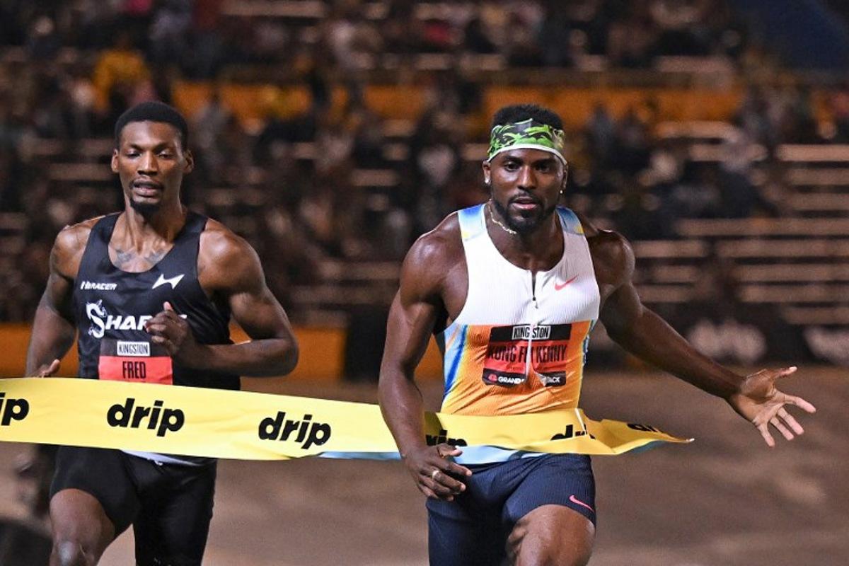 USA's Kenneth Bednarek (R) of team Nike crosses the finish line in first place ahead of USA's Fred Kerley (L) in the men's men 100m short sprint during the Grand Slam Track competition at the National Stadium in Kingston, Jamaica on April 4, 2025. Ricardo Makyn / AFP