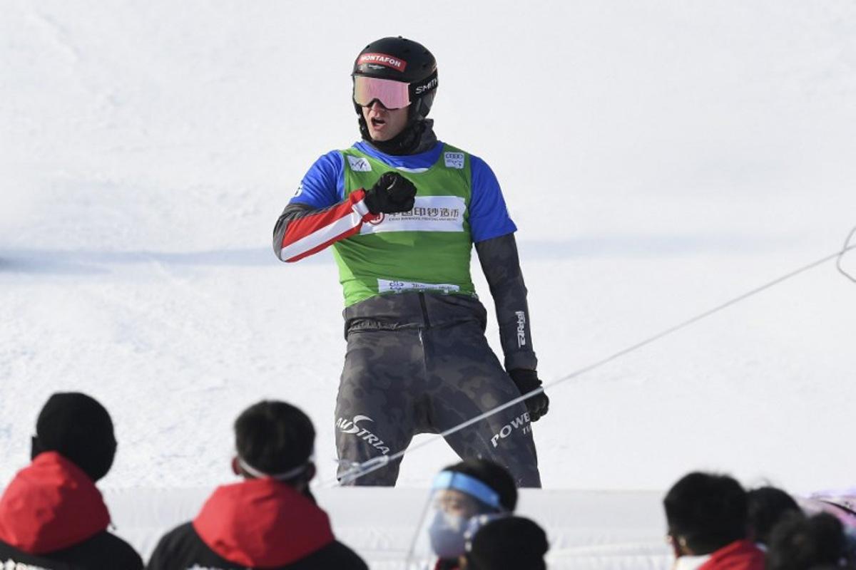 Austria's Alessandro Haemmerle celebrates after winning the men's snowboard cross finals during the FIS Snowboard Cross World Cup 2022, part of a 2022 Beijing Winter Olympic Games test event at the Genting Snow Park in Chongli county, Zhangjiakou city, China's Hebei province on November 28, 2021. WANG Zhao / AFP