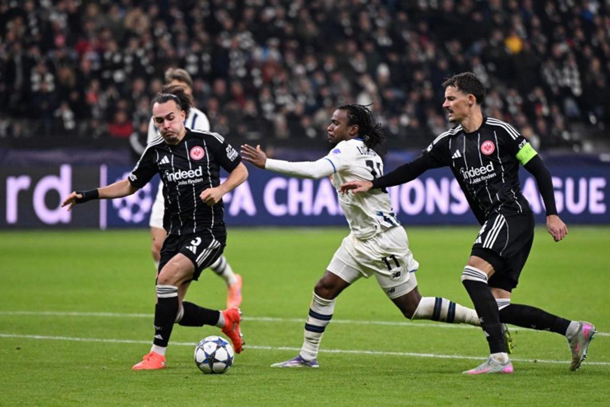 Atalanta's Nigerian forward #11 Ademola Lookman (C) vies for the ball with Frankfurt's German defender #04 Robin Koch (R) and Frankfurt's Belgian defender #03 Arthur Theate during the UEFA Champions League league phase day 5 football match between Eintracht Frankfurt and Atalanta Bergamo in Frankfurt, Germany, on November 26, 2025. Kirill KUDRYAVTSEV / AFP