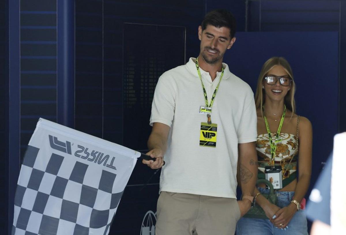 Belgian goalkeeper Thibaut Courtois practices waving the checked flag next to his wive Mishel Gerzig during the Sprint Race of the Formula One Belgian Grand Prix at the Spa-Francorchamps circuit in Spa, on July 26, 2025. STEPHANIE LECOCQ / POOL / AFP