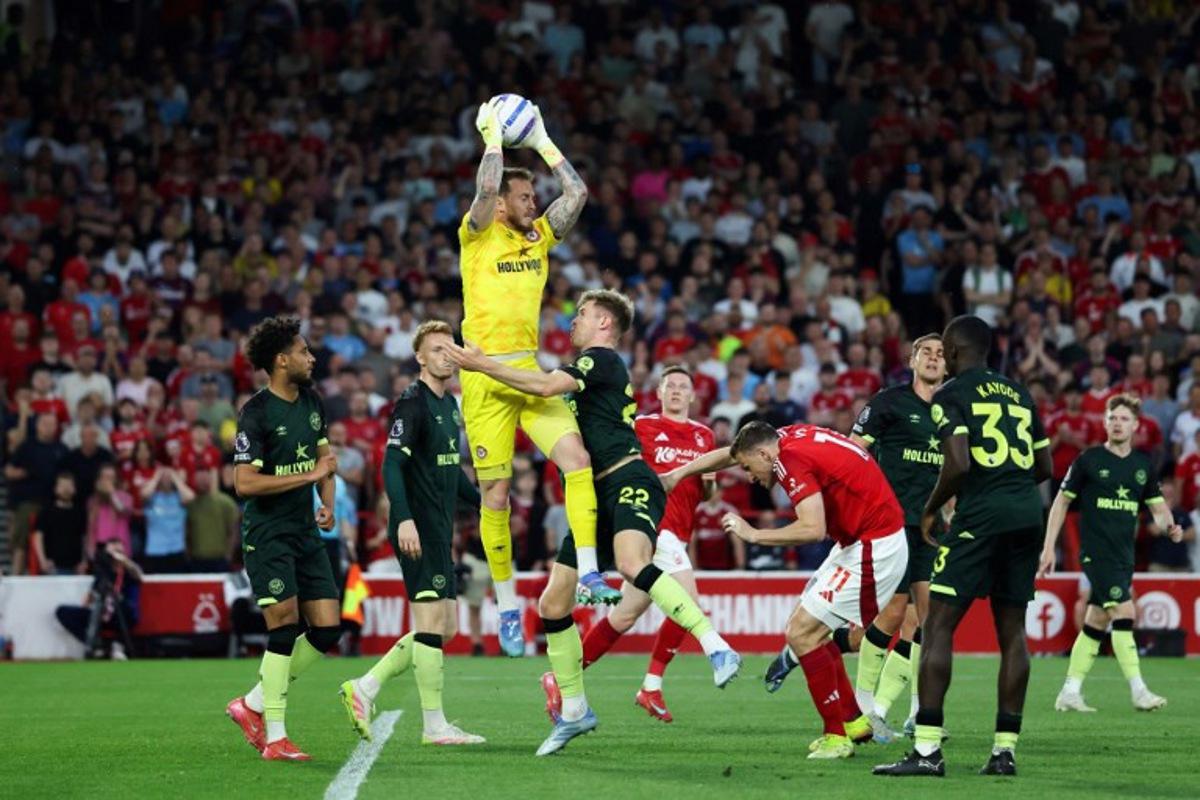 Brentford's Dutch goalkeeper #01 Mark Flekken (C) jumps to catch the ball during the English Premier League football match between Nottingham Forest and Brentford at The City Ground in Nottingham, central England, on May 1, 2025. Darren Staples / AFP
