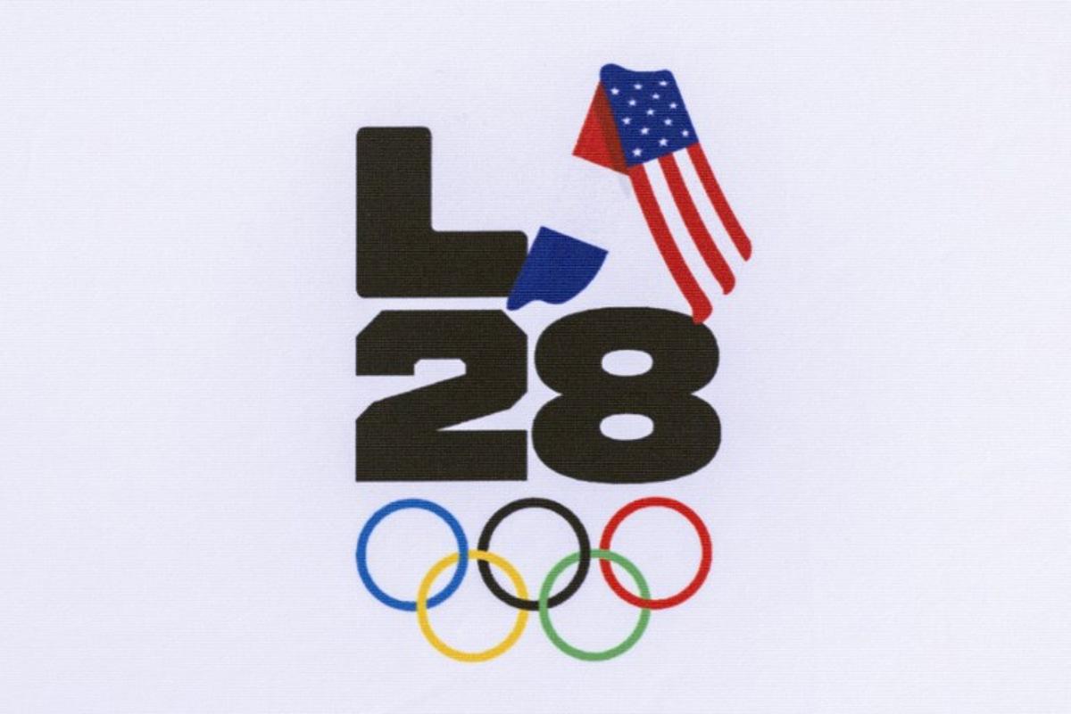 A LA28 (Los Angeles 2028) logo is pictured with French and US national flags during the event celebrating the arrival of the Olympic flag at Los Angeles International Airport (LAX) in Los Angeles, on August 12, 2024. Los Angeles will host the 2028 Summer Olympic Games. The arrival marks the official Olympic Flag's return to Los Angeles for the first time in 40 years. Etienne LAURENT / AFP