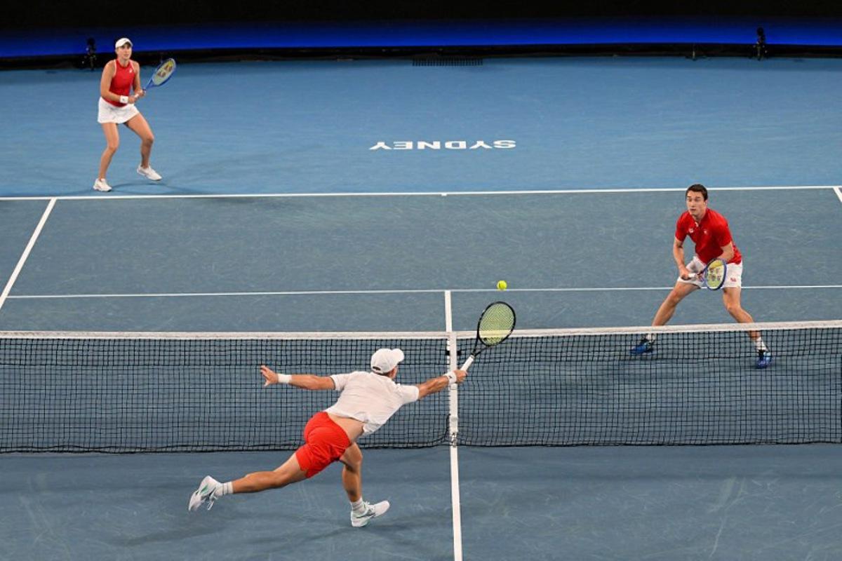 Poland's Jan Zielinski hits a return against Switzerland's Jakub Paul and Belinda Bencic during their mixed doubles match during the final at the United Cup tennis tournament in Sydney on January 11, 2026. Izhar KHAN / AFP