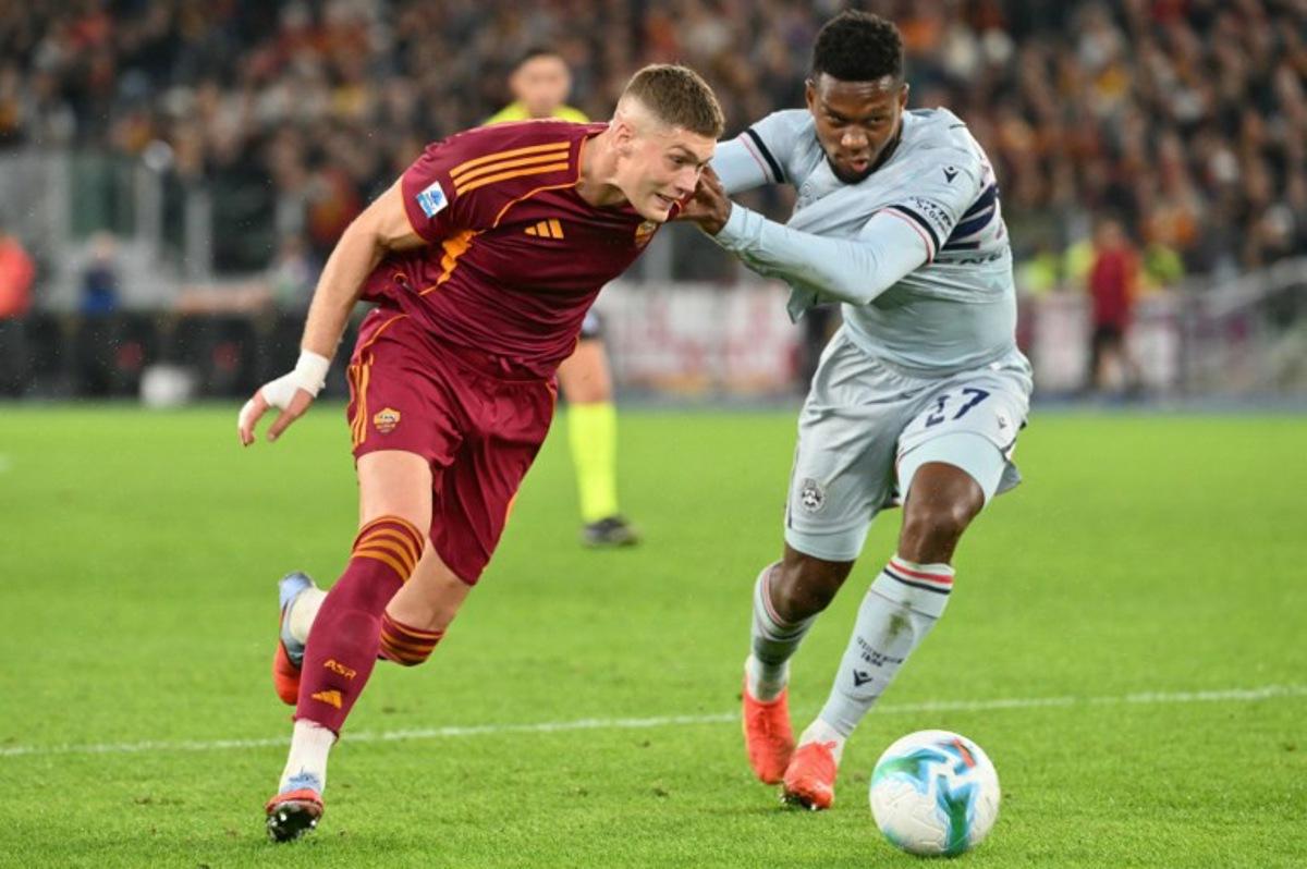 Roma's Ukrainian forward #09 Artem Dovbyk fights for the ball with Udinese's Belgian defender #27 Christian Kabasele during the Italian Serie A football match between AS Roma and Udinese at the Olympic Stadium in Rome on November 9, 2025. Alberto PIZZOLI / AFP
