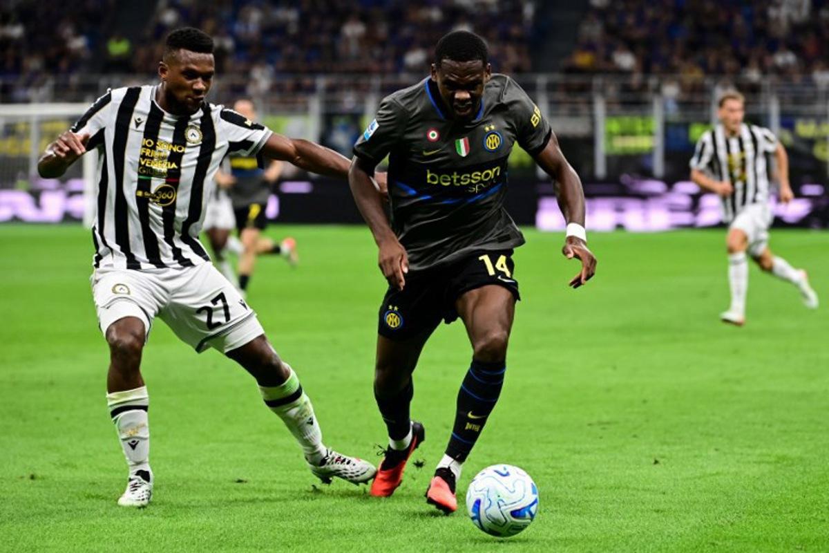 Udinese's Belgian defender #27 Christian Kabasele fights for the ball with Inter Milan's French forward #14 Ange-Yoan Bonny during the Italian Serie A football match between Inter Milan and Udinese at the San Siro Stadium in Milan, Italy on September 14, 2026. Piero CRUCIATTI / AFP