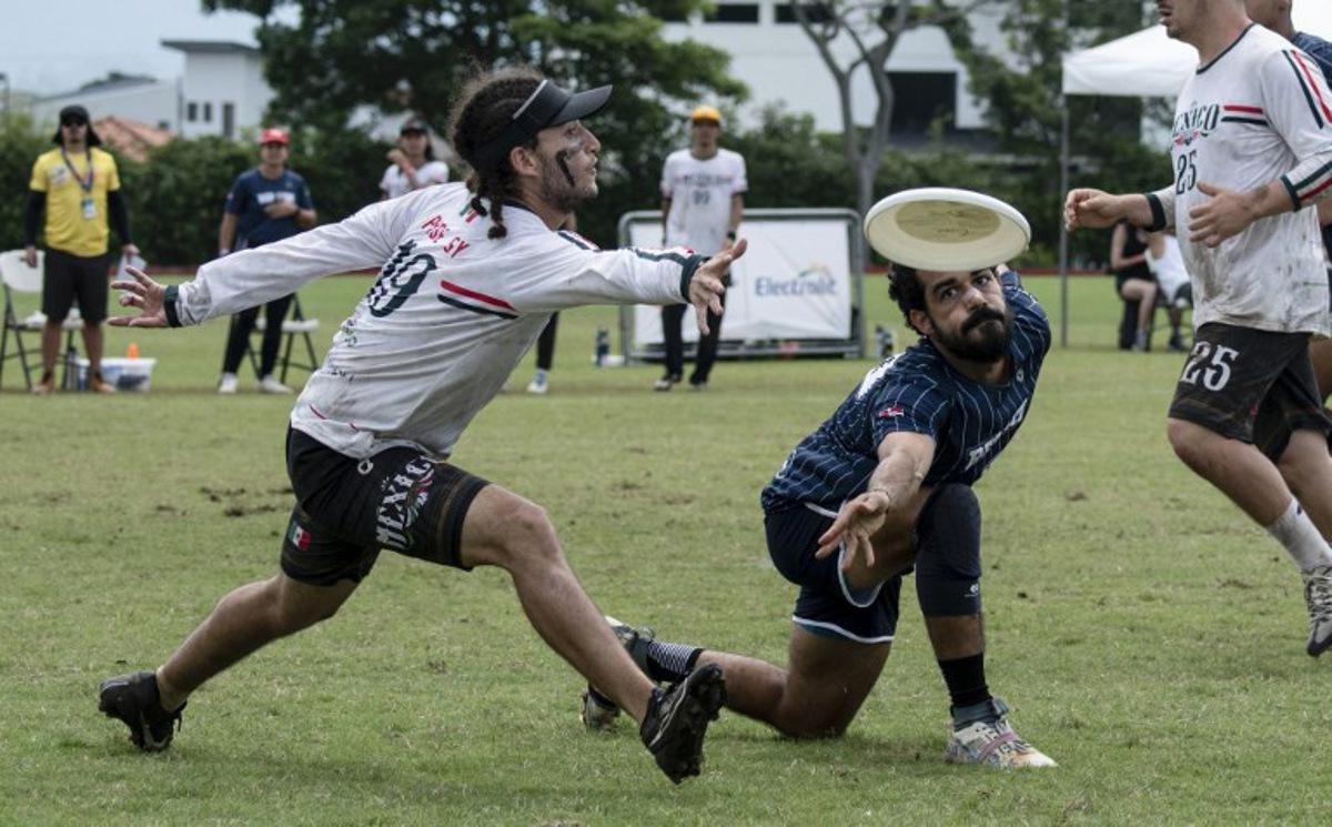 Mexico's Victor Bautista (L) and Dominican Republic's Alejandro Machado vie for the frisbee during the final of the Central American and Caribbean Ultimate 2024 Tournament between Mexico and the Dominican Republic in San Jose on July 21, 2024. Ezequiel BECERRA / AFP