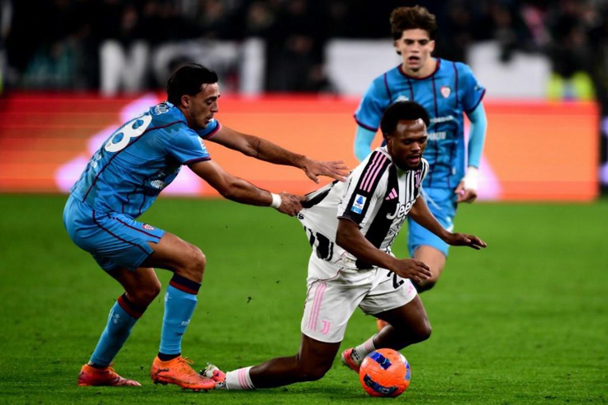 Cagliari's Italian defender #28 Gabriele Zappa and Juventus' Belgian forward #20 Lois Openda fight for the ball during the Italian Serie A football match between Juventus and Cagliari at the Allianz stadium in Turin on November 29, 2025. MARCO BERTORELLO / AFP
