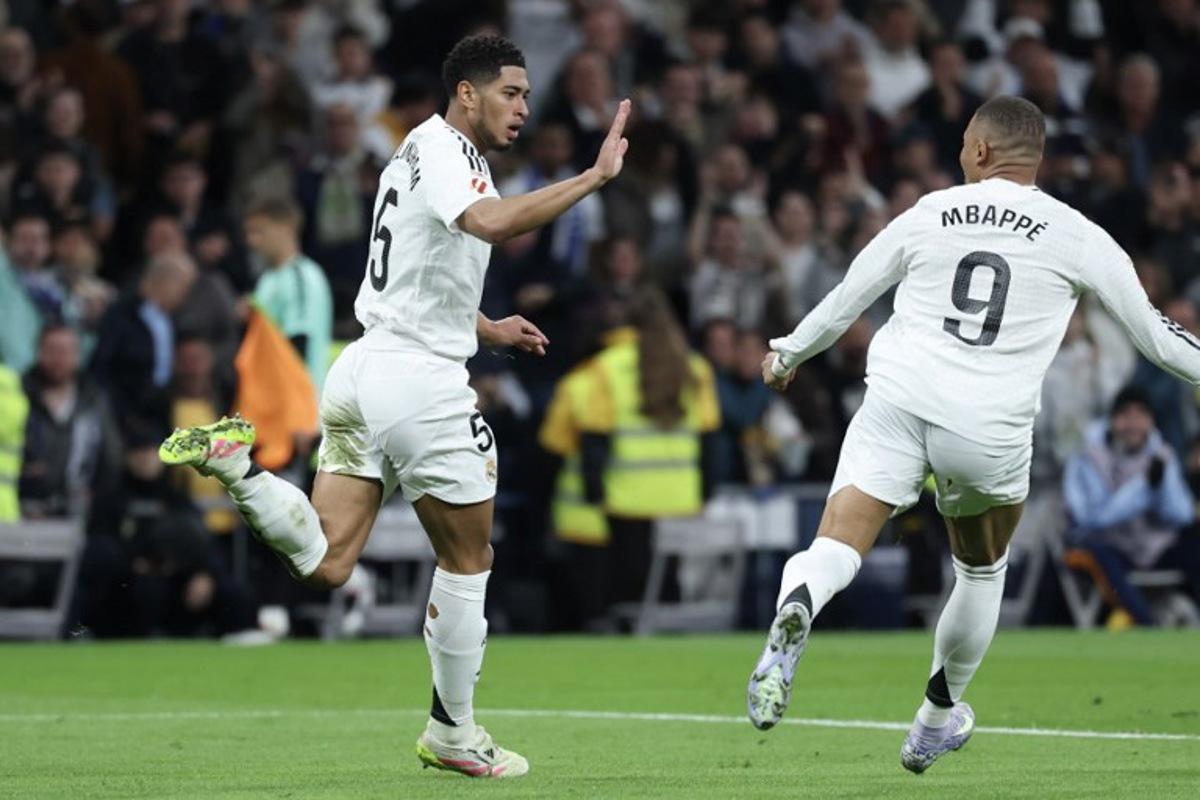 Real Madrid's English midfielder #05 Jude Bellingham (L) celebrates scoring their second goal with Real Madrid's French forward #09 Kylian Mbappe during the Spanish league football match between Real Madrid CF and Club Deportivo Leganes SAD at the Santiago Bernabeu stadium in Madrid on March 29, 2025. Thomas COEX / AFP