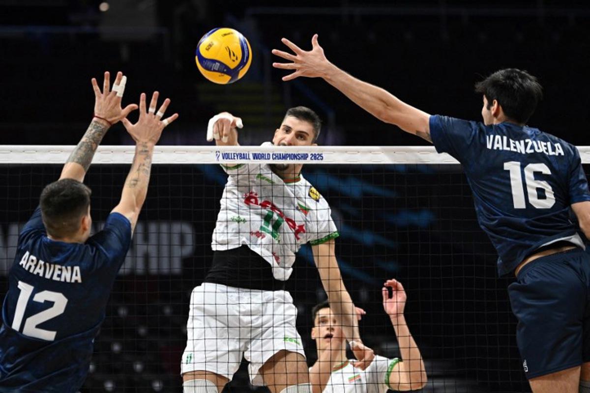 Bulgaria's Aleks Grozdanov (C) spikes the ball against Chile's Noe Aravena (L) and Vicente Valenzuela during their match at the Volleyball Men's World championship in Manila on September 17, 2025. Ted ALJIBE / AFP