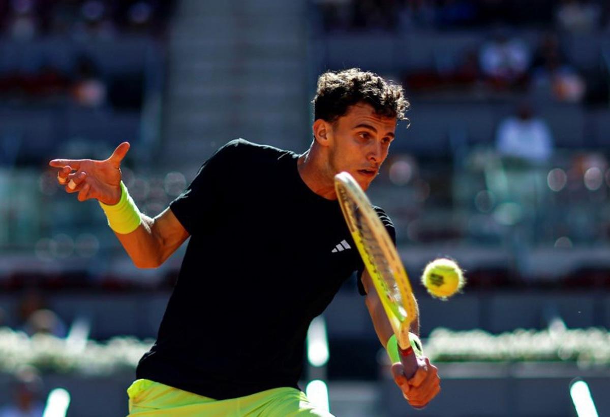 Argentina's Juan Manuel Cerundolo returns the ball to Russia's Daniil Medvedev during their 2025 ATP Tour Madrid Open tennis tournament third round singles match at the Caja Magica in Madrid, on April 27, 2025. OSCAR DEL POZO / AFP