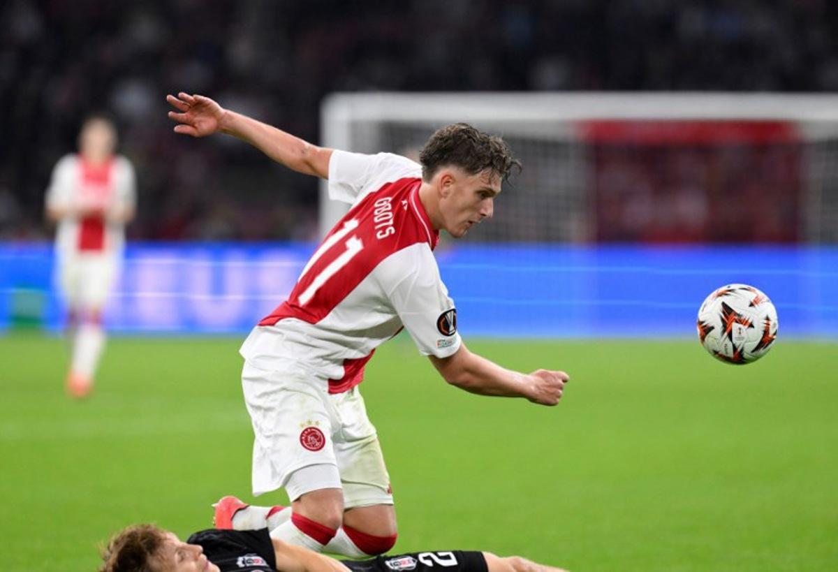 Besiktas' Norwegian defender #02 Jonas Svensson (L) tackles Ajax's Belgian forward #11 Mika Godts during the UEFA Europa League football match between Ajax Amsterdam and Besiktas at The Johan Cruijff Arena Stadium in Amsterdam on September 26, 2024. JOHN THYS / AFP