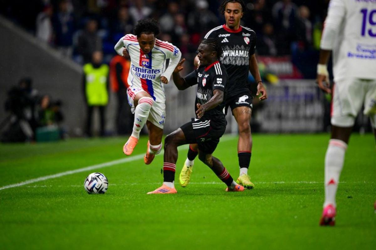 Lyon's Belgium forward #11 Malick Fofana fights for the ball with Strasbourg's Ivorian midfielder #42 Abdoul Ouattara during the French L1 football match between Olympique Lyonnais (OL) and RC Strasbourg Alsace at the Parc Olympique Lyonnais stadium in Decines-Charpieu, central-eastern France, on October 26, 2025. OLIVIER CHASSIGNOLE / AFP