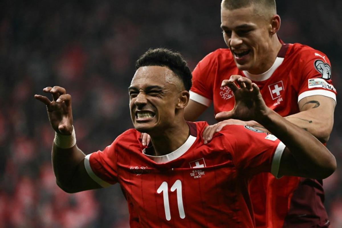 Switzerland's forward #11 Dan Ndoye (L) celebrates after scoring his team's third goal during the FIFA World Cup 2026 Group B European qualification football match between Switzerland and Sweden at the Geneva stadium, in Geneva, on November 15, 2025. Fabrice COFFRINI / AFP