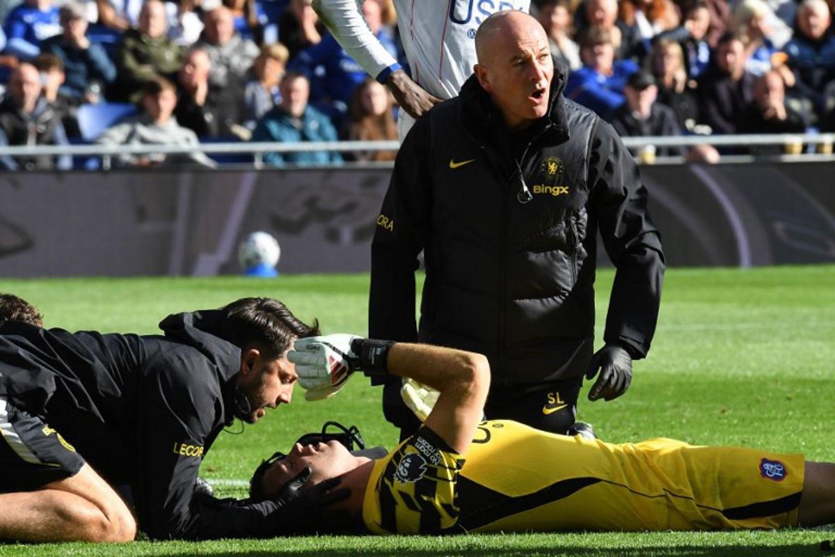 Chelsea's Argentinian goalkeeper #26 Emiliano Martinez is treated after picking up an injury during the English Premier League football match between Everton and Chelsea at Hill Dickinson Stadium in Liverpool, north west England on October 17, 2026. PETER POWELL / AFP