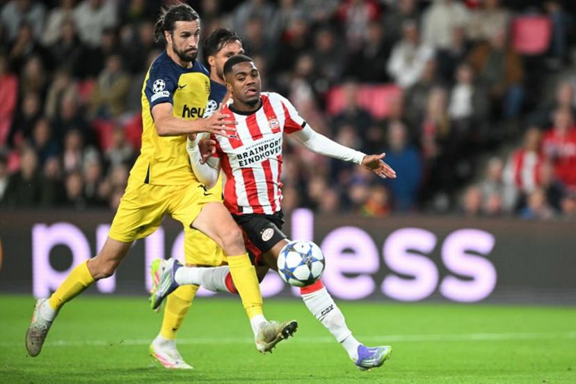 PSV Eindhoven's Dutch forward #21 Myron Boadu (R) and Union's English defender #16 Christian Burgess fight for the ball during the UEFA Champions League first round day 1 football match between PSV Eindhoven and Union Saint-Gilloise at the Philips Stadium, in Eindhoven on September 16, 2025. NICOLAS TUCAT / AFP