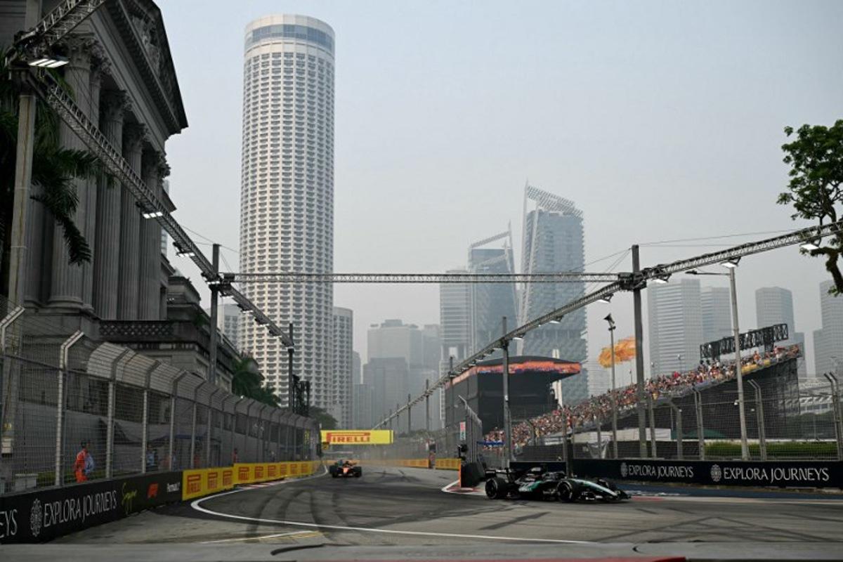 Mercedes' British driver George Russell (R) drives during a practice session ahead of the Formula One Singapore Grand Prix at the Marina Bay Street Circuit in Singapore on October 9, 2026. Roslan RAHMAN / AFP
