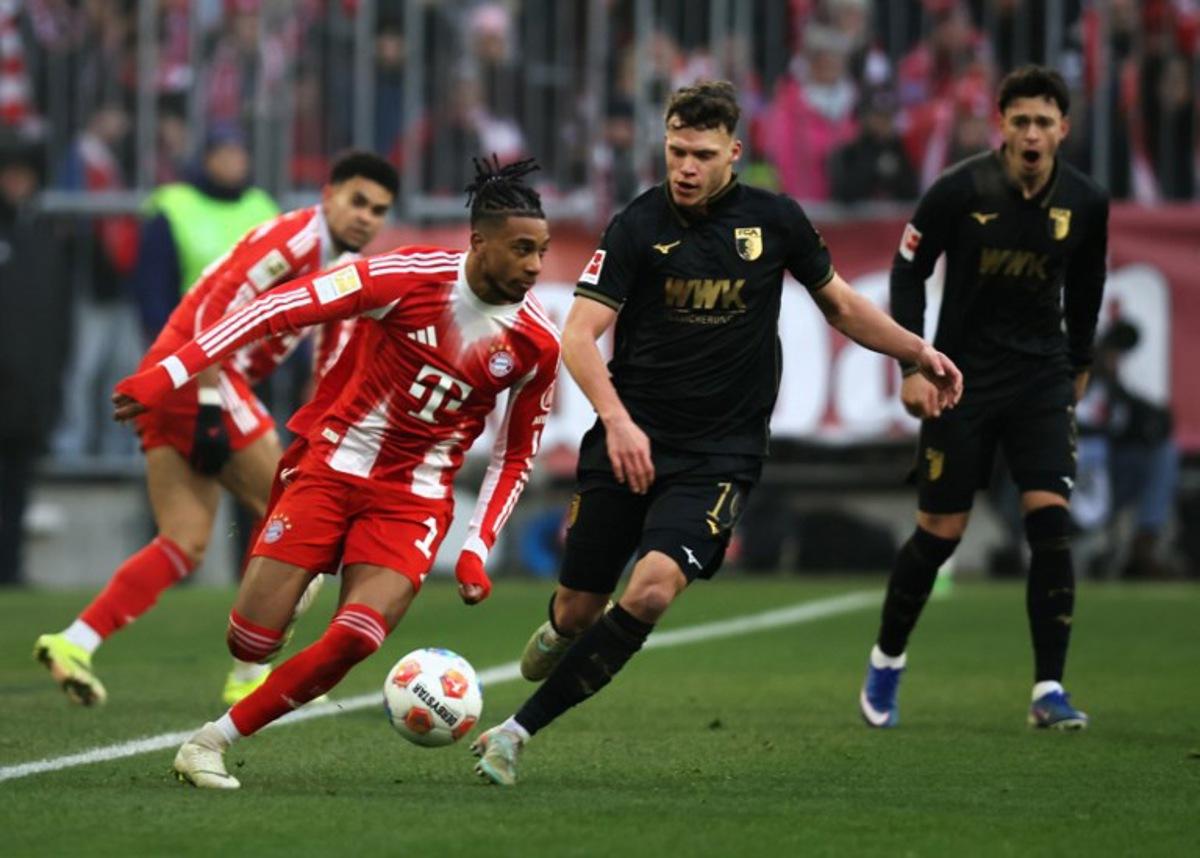 Bayern Munich's French midfielder #17 Michael Olise and Augsburg's German midfielder #19 Robin Fellhauer vie for the ball during the German first division Bundesliga football match between FC Bayern Munich and FC Augsburg in Munich, southern Germany, on January 24, 2026. Alexandra BEIER / AFP