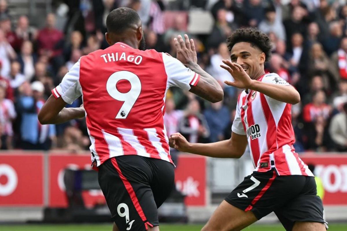 Brentford's Brazilian striker #09 Igor Thiago celebrates with Brentford's German midfielder #07 Kevin Schade after scoring the opening goal of the English Premier League football match between Brentford and Manchester United at the Gtech Community Stadium in London on September 27, 2025. JUSTIN TALLIS / AFP
