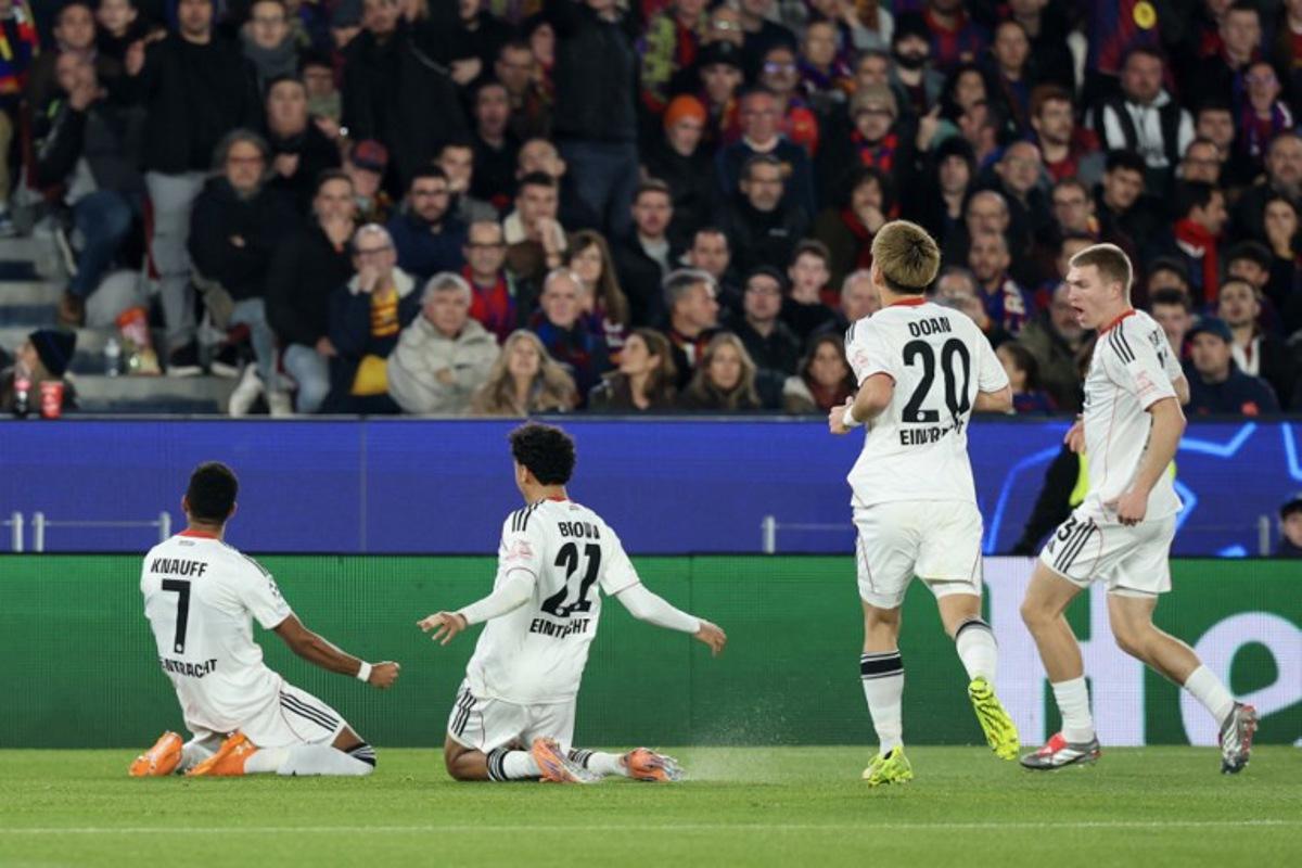 Frankfurt's German forward #07 Ansgar Knauff (L) celebrates scoring his team's first goal during the UEFA Champions League league phase day 6 football match between FC Barcelona and Eintracht Frankfurt at Camp Nou Stadium in Barcelona on December 9, 2025. Lluis GENE / AFP
