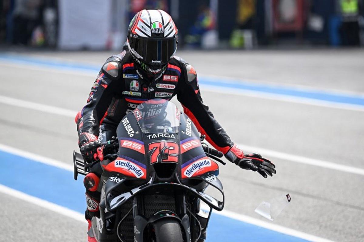 Aprilia Racing's Italian rider Marco Bezzecchi rips a strip off his visor during the free practice 1 session at the Buriram International Circuit in Buriram on February 27, 2026, ahead of the Thailand MotoGP Grand Prix. Lillian SUWANRUMPHA / AFP