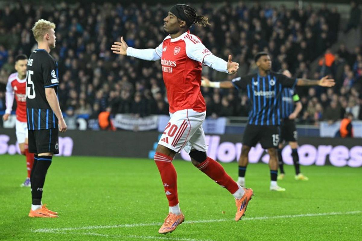 Arsenal's English forward #20 Noni Madueke (C) celebrates after scoring the Arsenal's second goal during the UEFA Champions League, league phase - matchday 6, football match between Club Brugge and Arsenal at the Jan Breydel stadium in Bruges on December 10, 2025. NICOLAS TUCAT / AFP