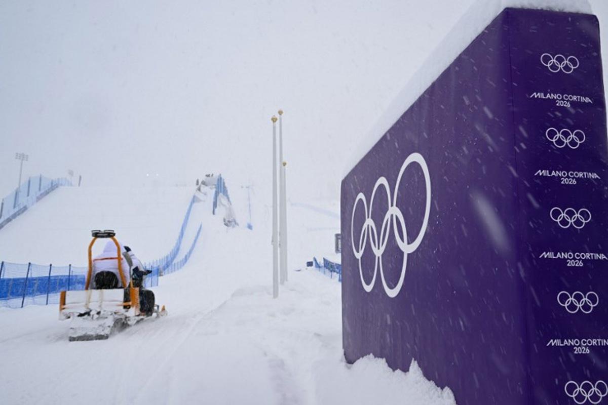 A snowmobile drives past a placard displaying olympic rings, shortly after the cancellation due to weather conditions of the snowboard women's slopestyle final run 1 during the Milano Cortina 2026 Winter Olympic Games at Livigno Snow Park, in Livigno (Valtellina), on February 17, 2026. Kirill KUDRYAVTSEV / AFP
