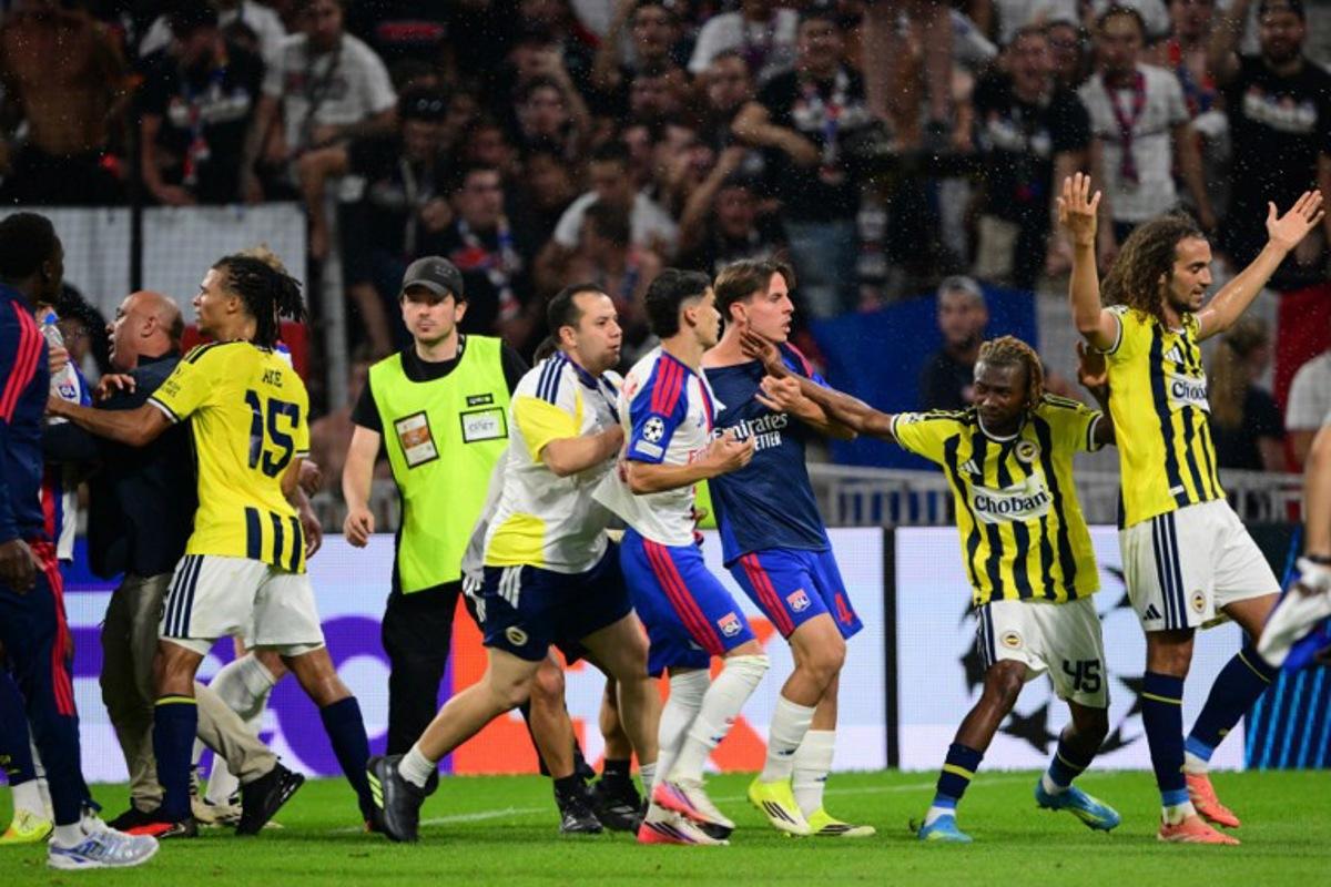 Fenerbahce's Malian forward #45 Nene Dorgeles (2R) tried to seperate Fenerbahce's French midfielder #06 Matteo Guendouzi (R) and Lyon's players after the final whistle at the end of the UEFA Champions League qualifying playoff - second leg football match between Olympique Lyonnais (OL) and Fenerbahce SK at the Groupama Stadium in Decines-Charpieu, central-eastern France, on August 26, 2026. Olivier CHASSIGNOLE / AFP