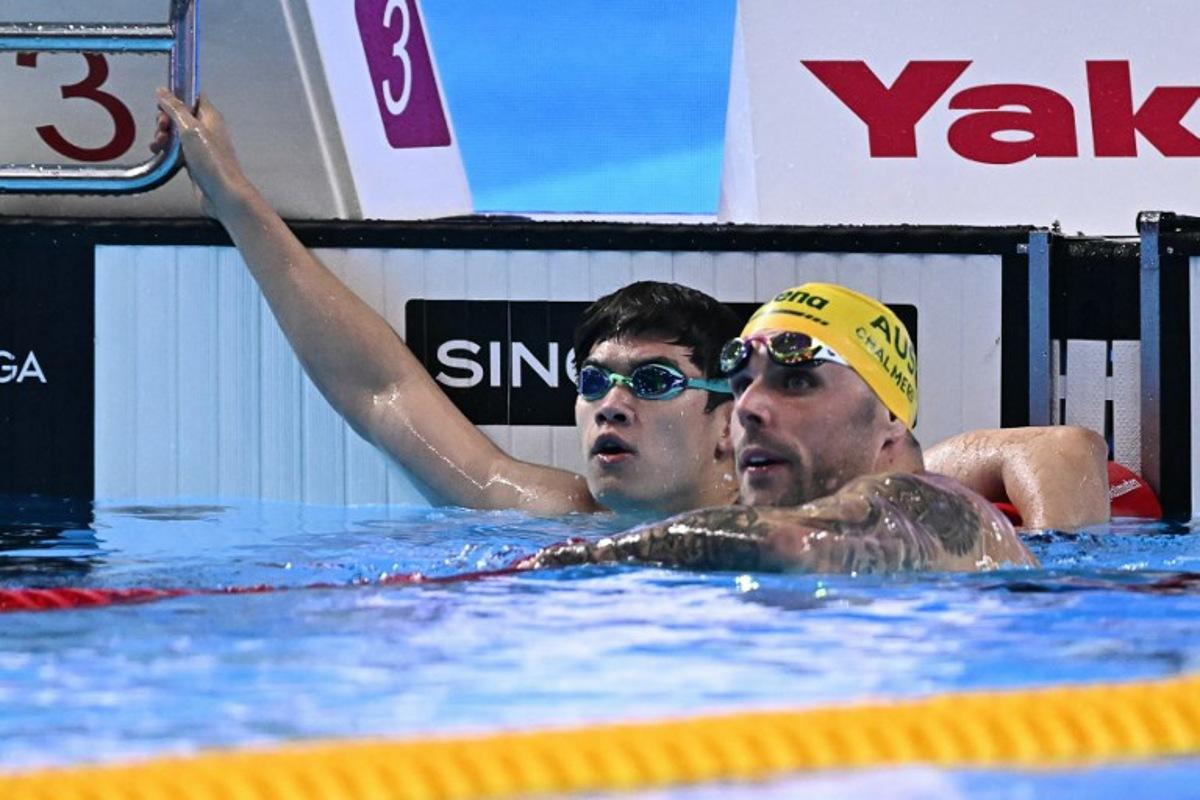 China's swimmer Pan Zhanle (L) and Australia's swimmer Kyle Chalmers react after a semi-final of the men's 100m freestyle swimming event during the 2025 World Aquatics Championships in Singapore on July 30, 2025. MANAN VATSYAYANA / AFP