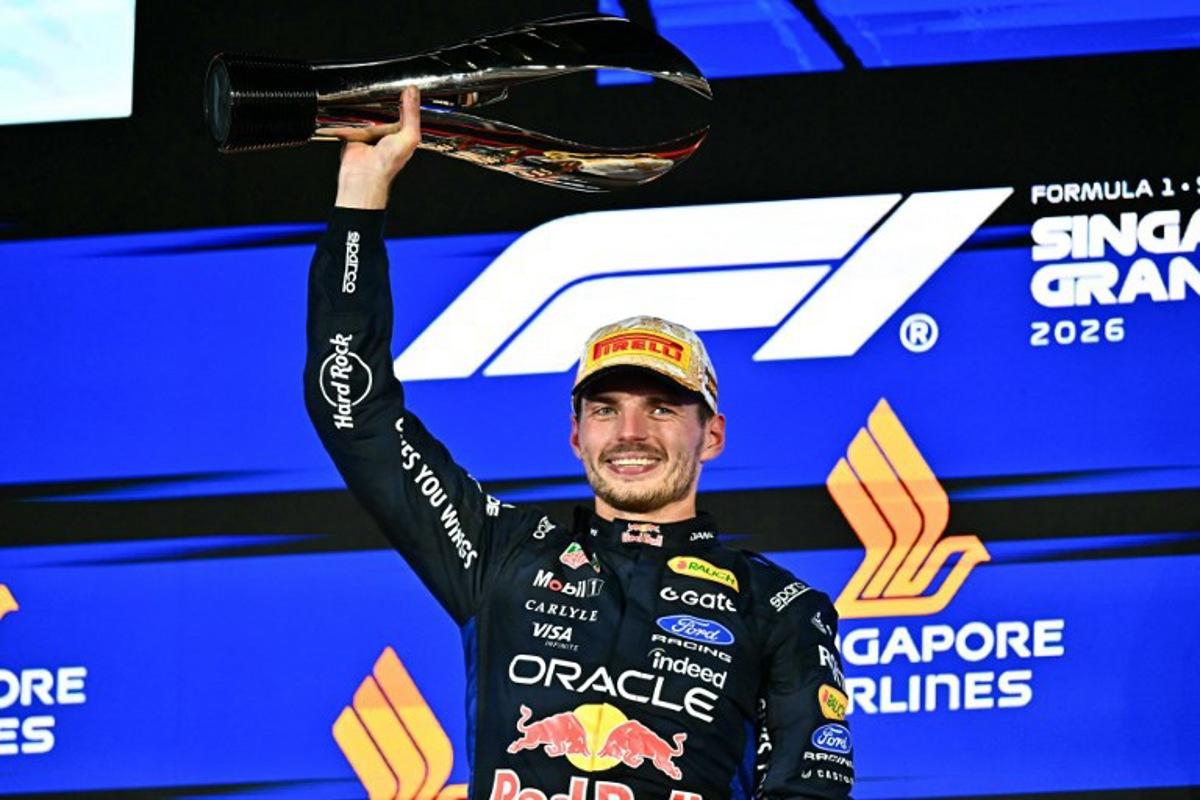 Winner Red Bull Racing's Dutch driver Max Verstappen lifts his trophy as he celebrates on the podium after the Formula One Singapore Grand Prix at the Marina Bay Street Circuit in Singapore on October 11, 2026. Lillian SUWANRUMPHA / AFP