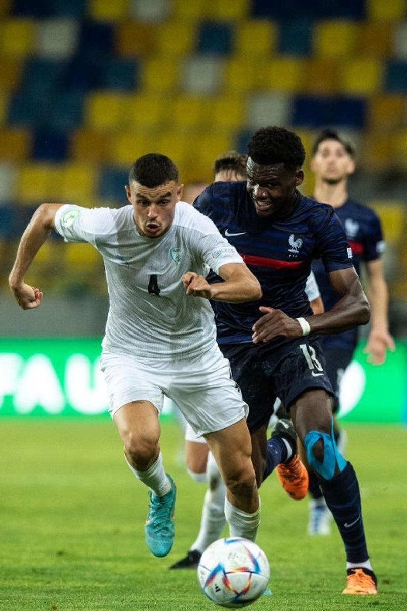 Israel's defender Stav Lemkin (L) and France's Ange-Yoan Bonny vie for the ball during the UEFA Under-19 European Championship semi-final football match between France and Israel at the DAC Arena in Dunajska Streda, Slovakia on June 28, 2022. VLADIMIR SIMICEK / AFP