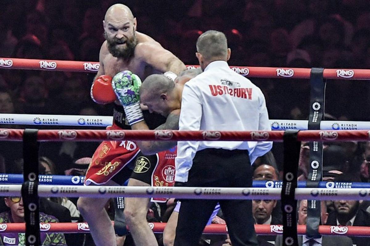 Britain's Tyson Fury (red) and Ukraine's Oleksandr Usyk (blue) compete during their heavyweight world championship rematch at the Kingdom Arena in Riyadh on December 22, 2024. AFP