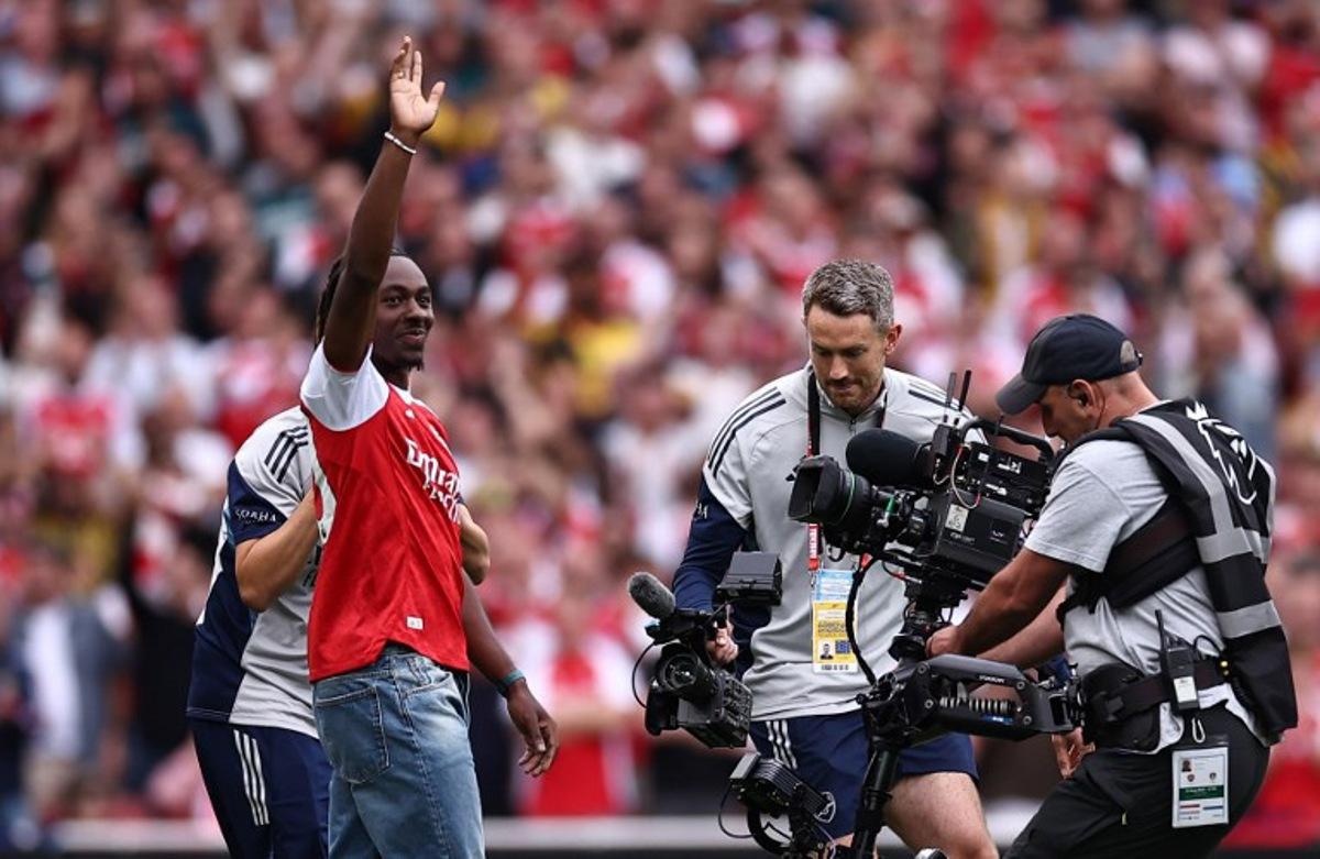 Eberechi Eze waves to the crowd as he is unveiled as a new signing ahead of the English Premier League football match between Arsenal and Leeds United at the Emirates Stadium in London on August 23, 2025. HENRY NICHOLLS / AFP