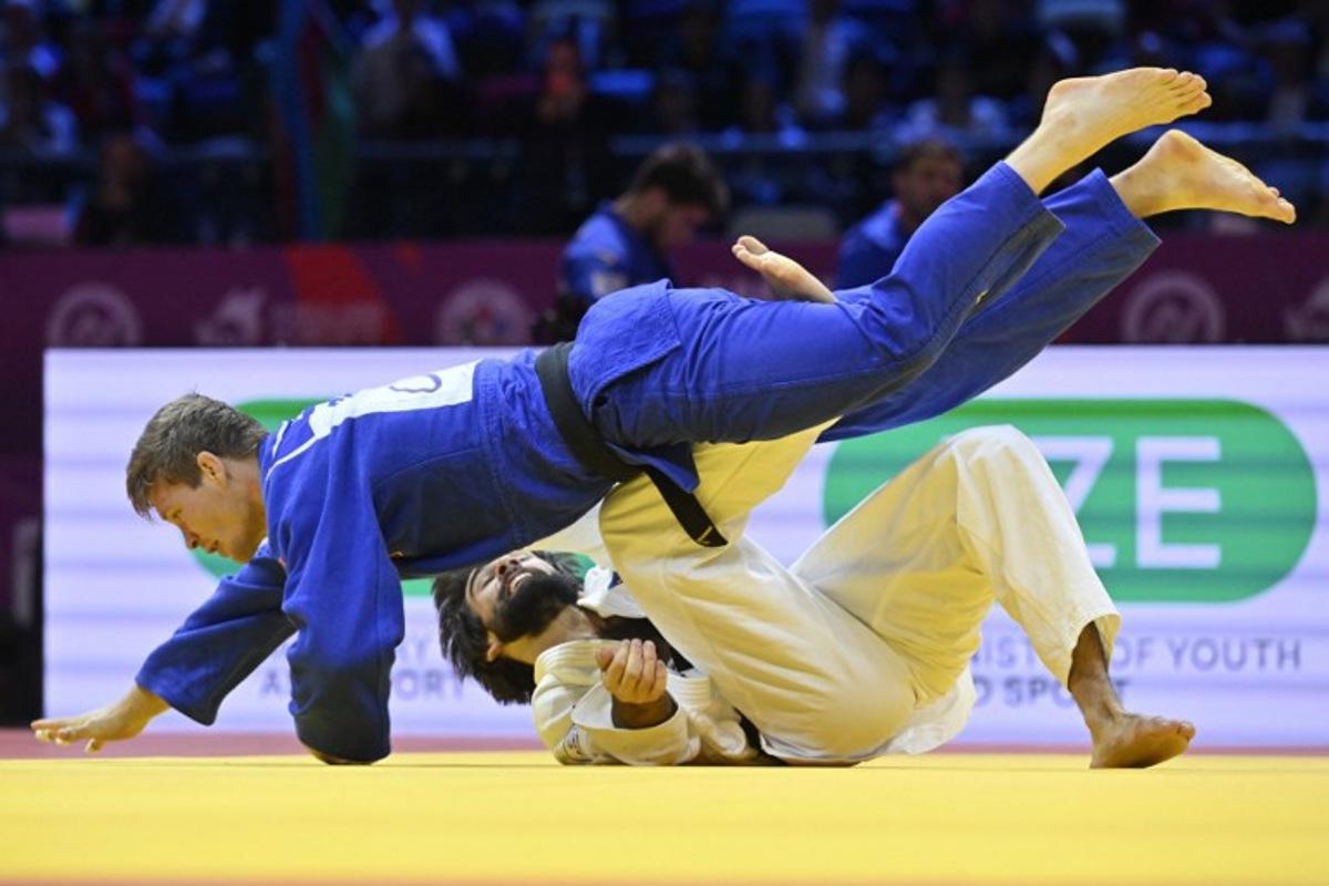 Azerbaijan's Zelim Tckaev (white) competes against Belgium's Matthias Casse in the men's under 81 kg quarter-final at the World Judo Championships in Baku on October 7, 2026. Alexander NEMENOV / AFP